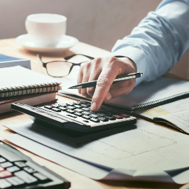 man using a calculator at a desk