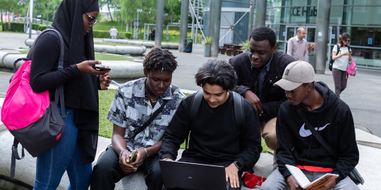 five university students working together outside