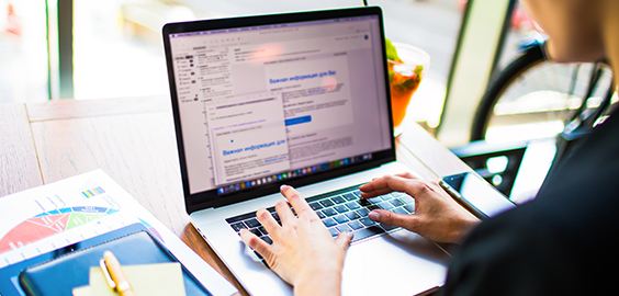 hands typing on keyboard next to notepad