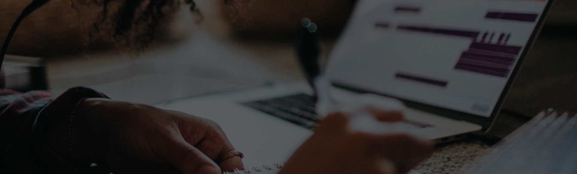 Page banner - student working on an assignment with a laptop in the background.