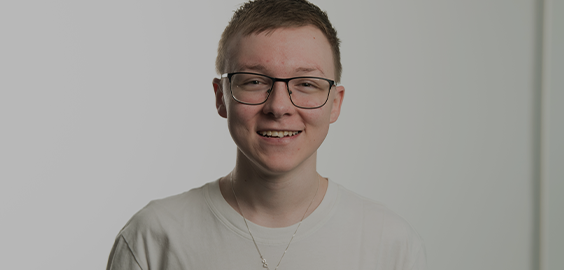 Student wearing glasses and white tshirt smiling