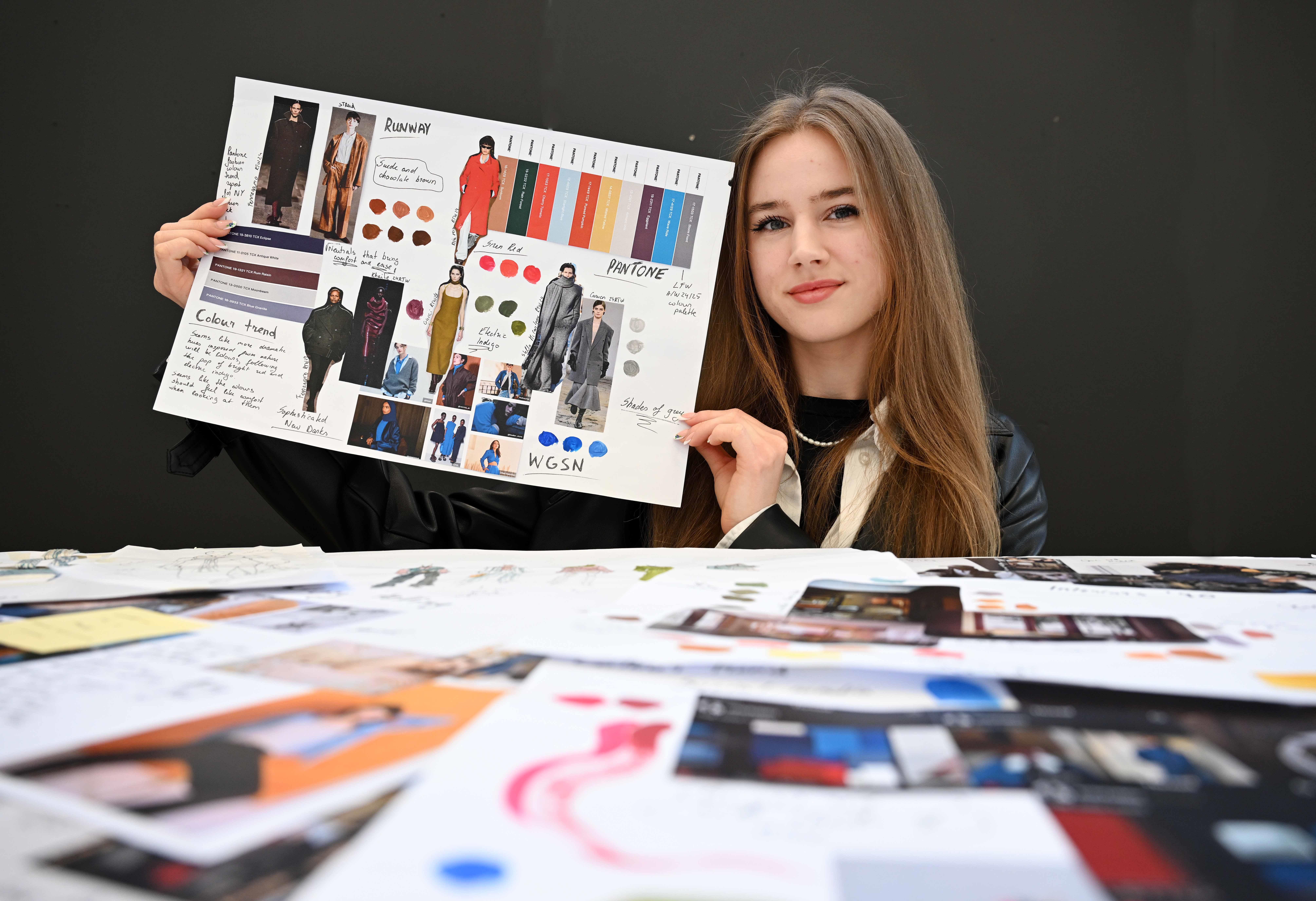 student with design work and portfolio