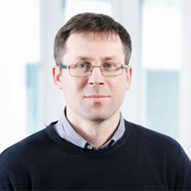 a man in glasses looking at the camera