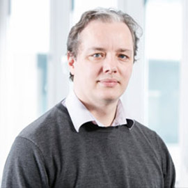 a man standing in front of a window posing for the camera