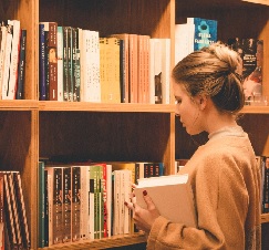 a person standing in front of a book shelf