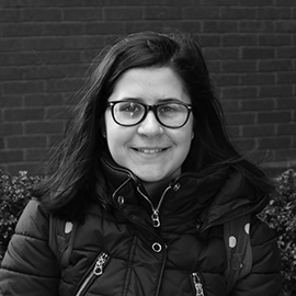 a person standing in front of a brick building