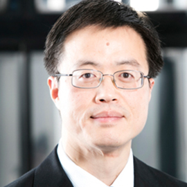 a man wearing a suit and tie smiling at the camera