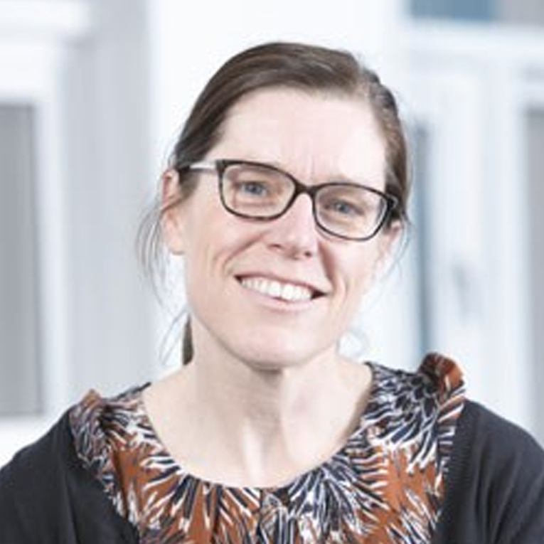 a woman in glasses looking at the camera