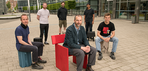 Academic Anthony Forsyth sat on chair on campus surrounded by other people