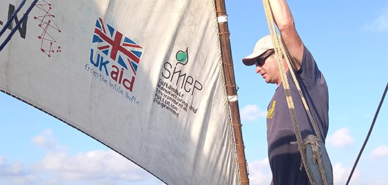 Academic Simon Scott Harden stood on a boat next to the sail