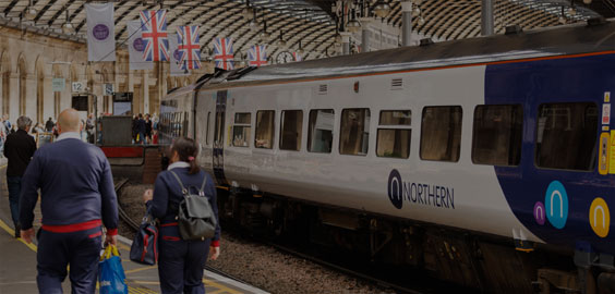 Image of a train at the platform in Newcastle Central Station and people on the platform