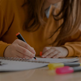 Image of student writing in a notebook