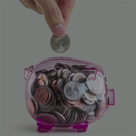 Image of a hand putting coins into a piggy bank